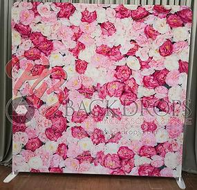 Pink and white floral photo booth backdrop – lush arrangement of large roses and peonies in soft pastel tones covering the full panel, standing on floor with gray curtain behind, ideal for romantic weddings, bridal showers, baby showers, or elegant feminine events