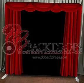 Red velvet curtain photo booth backdrop – elegant scalloped top drape with rich crimson fabric panels framing a black center opening, standing on floor with gray curtain behind, perfect for theater, formal wedding, gala, or classic event setups