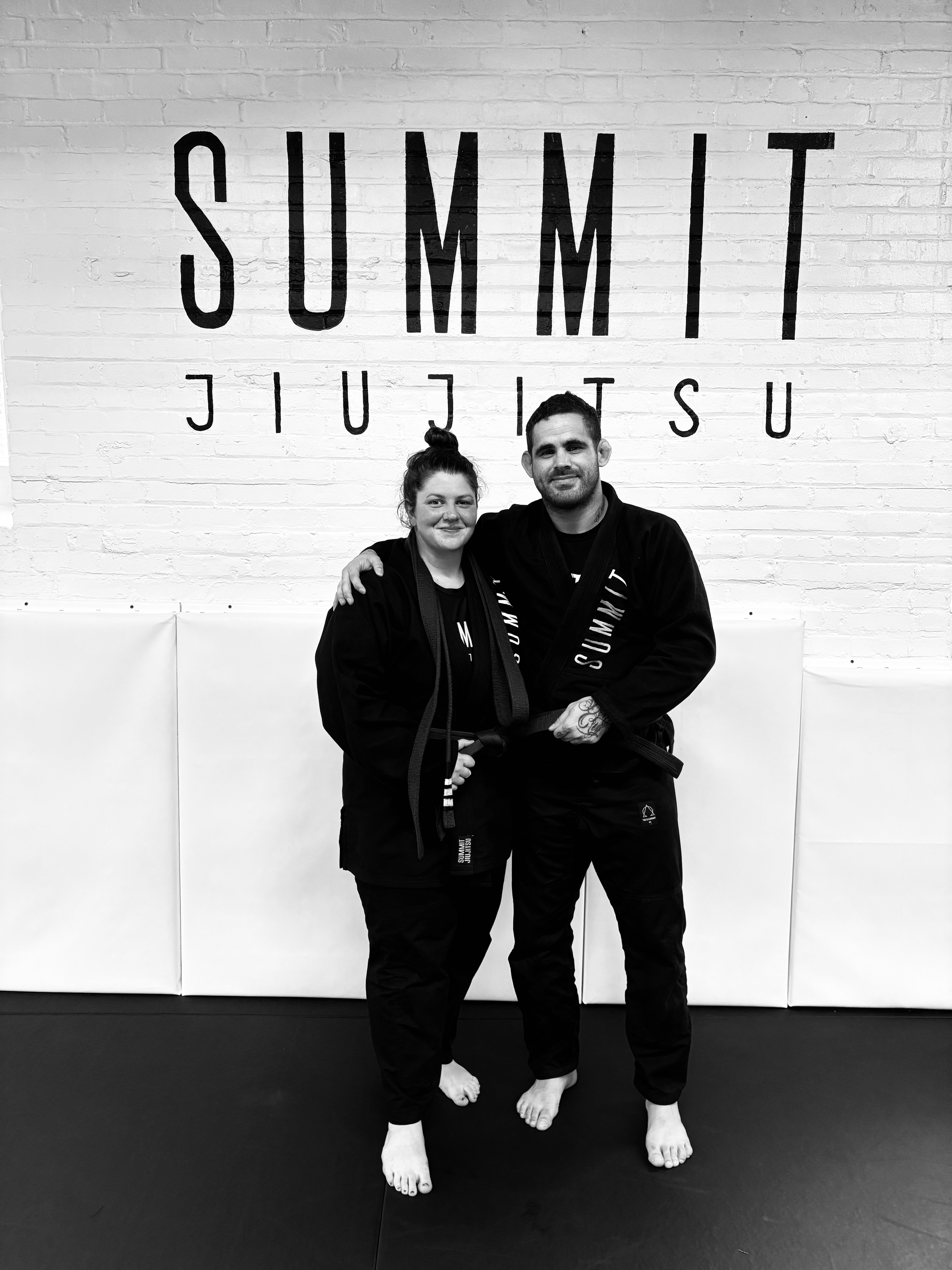 Black and white photo of a beginner learning Brazilian Jiu-Jitsu from a coach