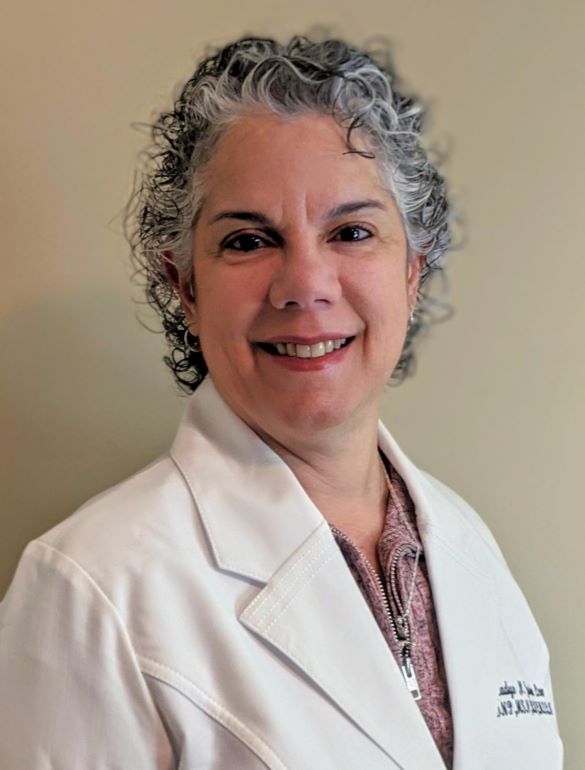 short-haired black cat besides brown wooden table