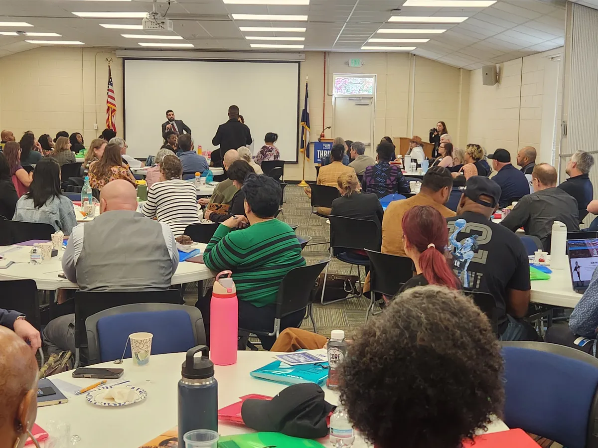 Community members and local entrepreneurs collaborating around a workshop table at Wezesha Dada Center
