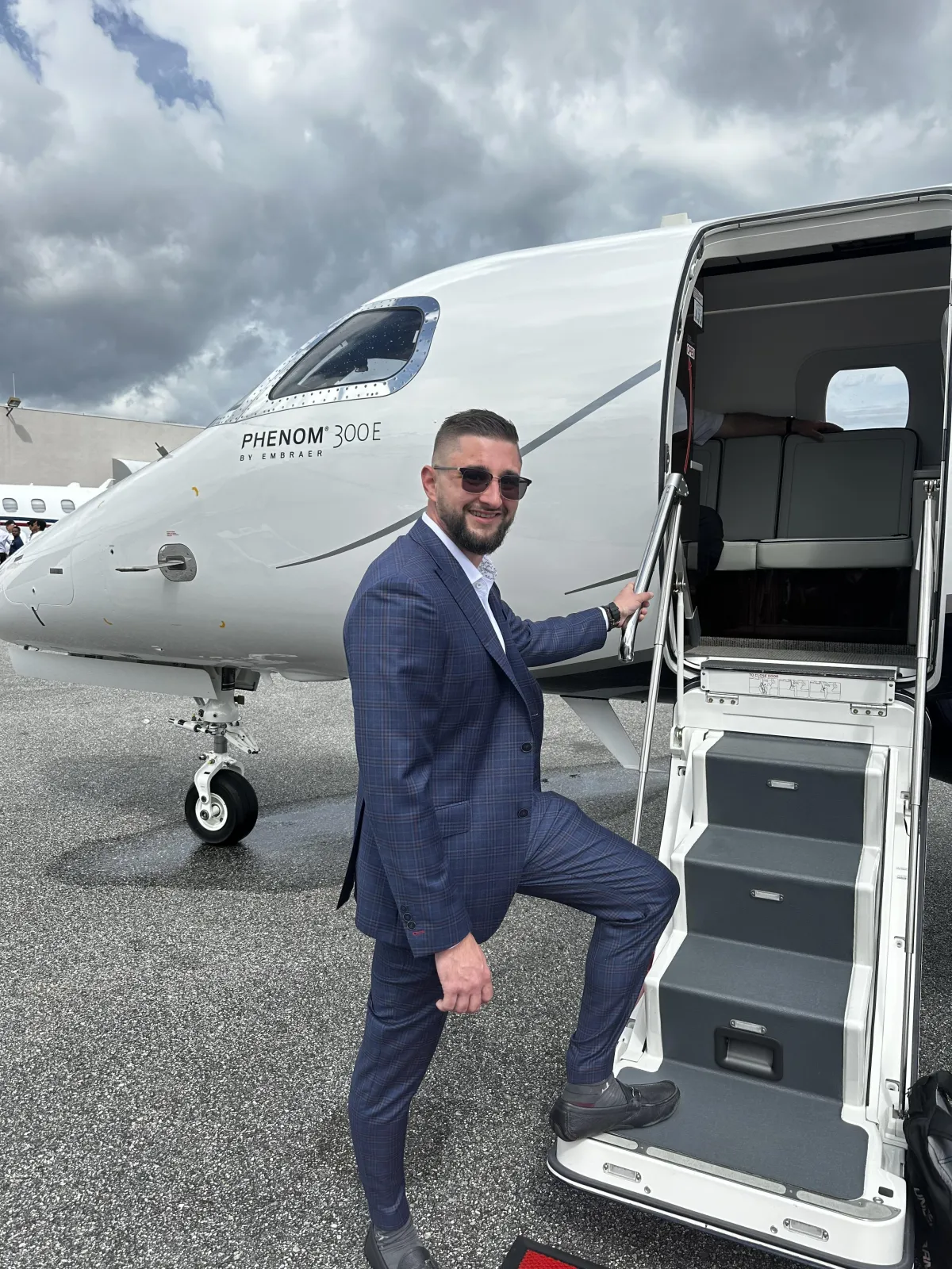 Portrait of Zach in lifestyle setting holding a phone, candid and engaging, warm natural window light, shallow depth of field, modern editorial photographic style that invites connection.