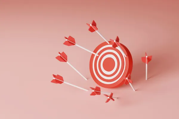 A red and white target with several red arrows missing the bullseye, scattered around it on a pink background.