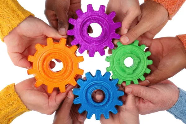 Hands holding together colorful gears, symbolizing leaders with great systems