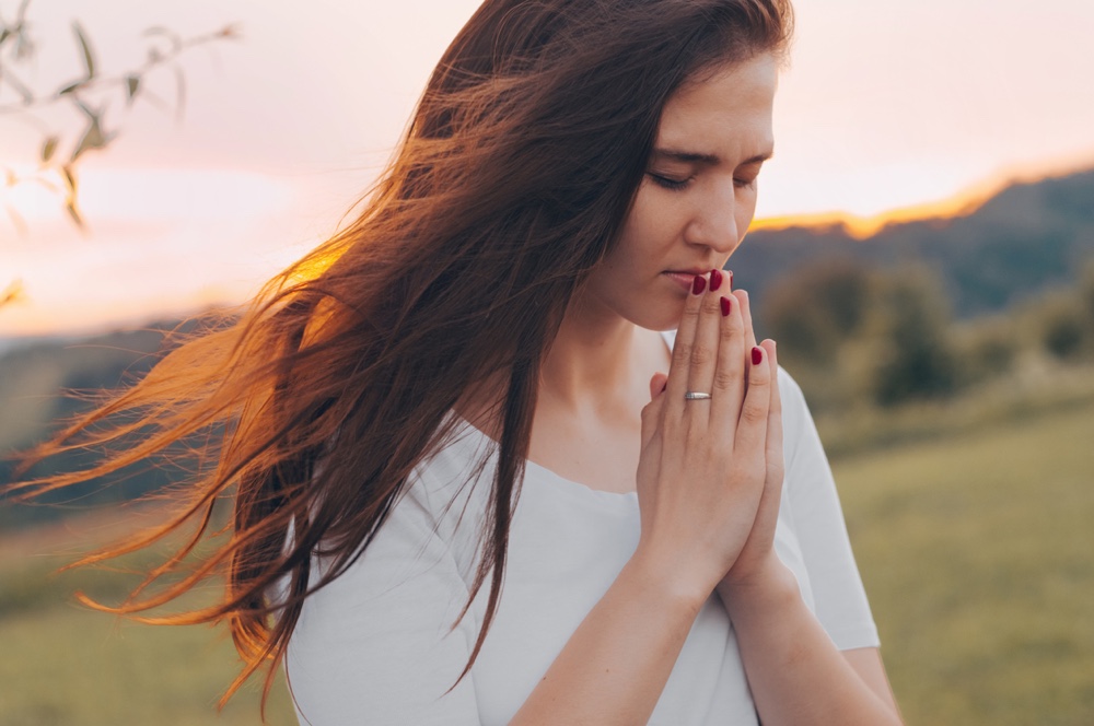 A diverse group of adults meditating in a sunlit forest clearing, surrounded by lush greenery and dappled sunlight, all appearing calm and rejuvenated, with yoga mats and relaxed postures, captured in a natural, documentary style.