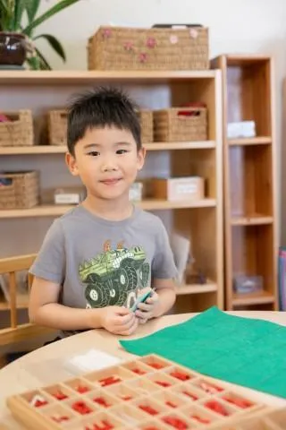 Early childhood student working independently with Montessori moving alphabet materials at Wilkes Avenue campus 