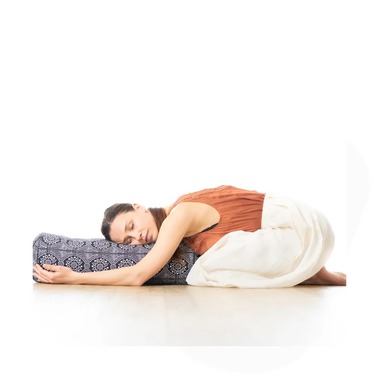 person in supported yin childs pose in yoga
