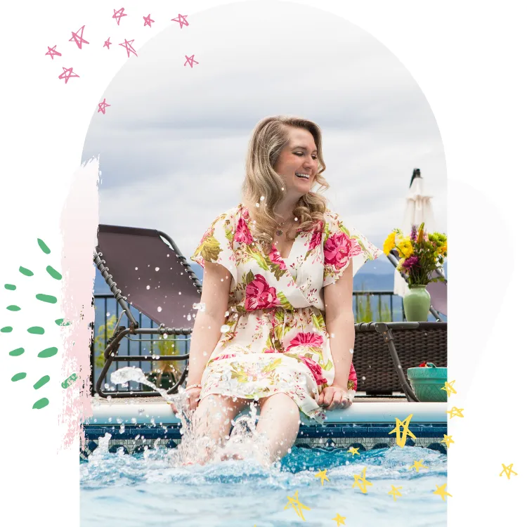 Woman sitting poolside with legs in the water, smiling with joy—symbolizing midlife empowerment, menopause self-care, emotional freedom, and the joy of reconnecting with yourself.