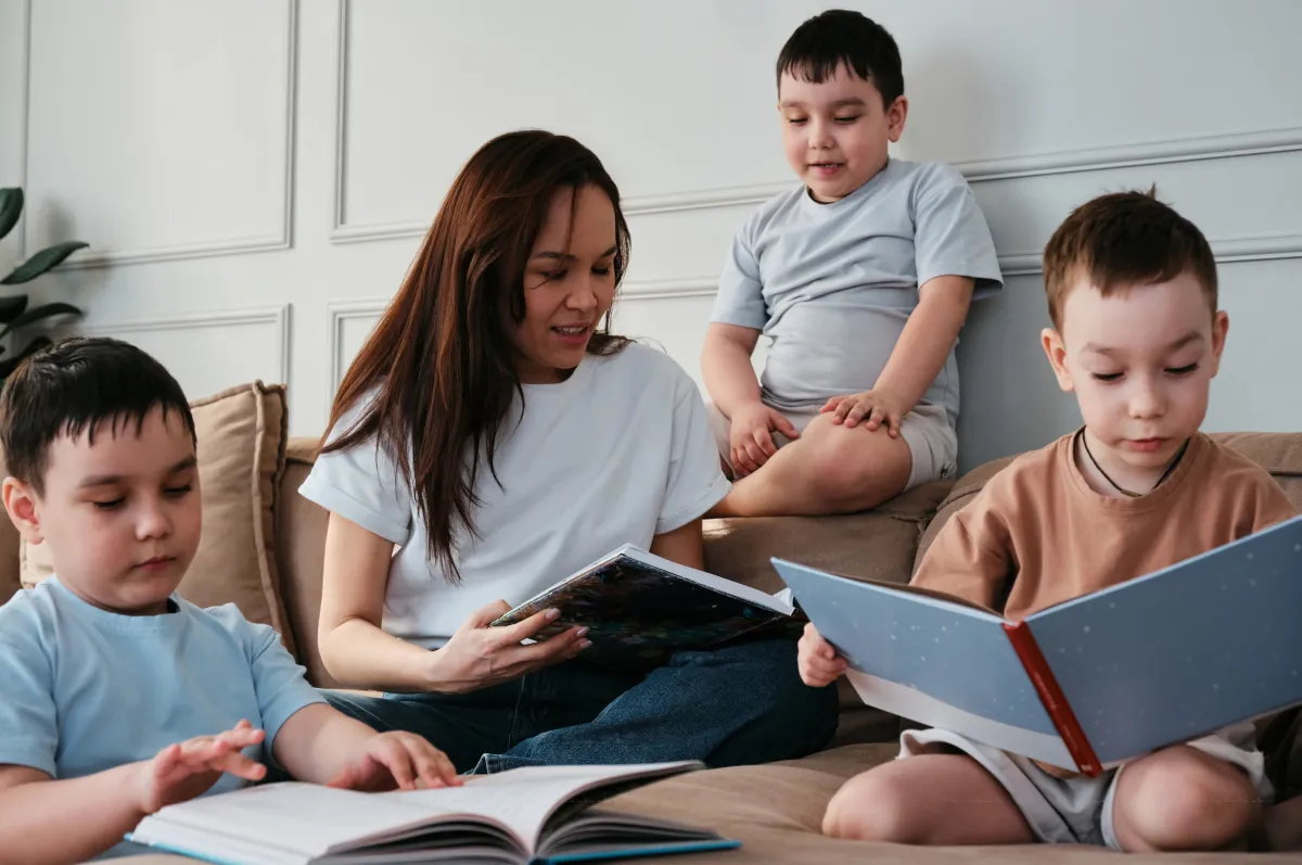 a sitter helping three different children read their own books