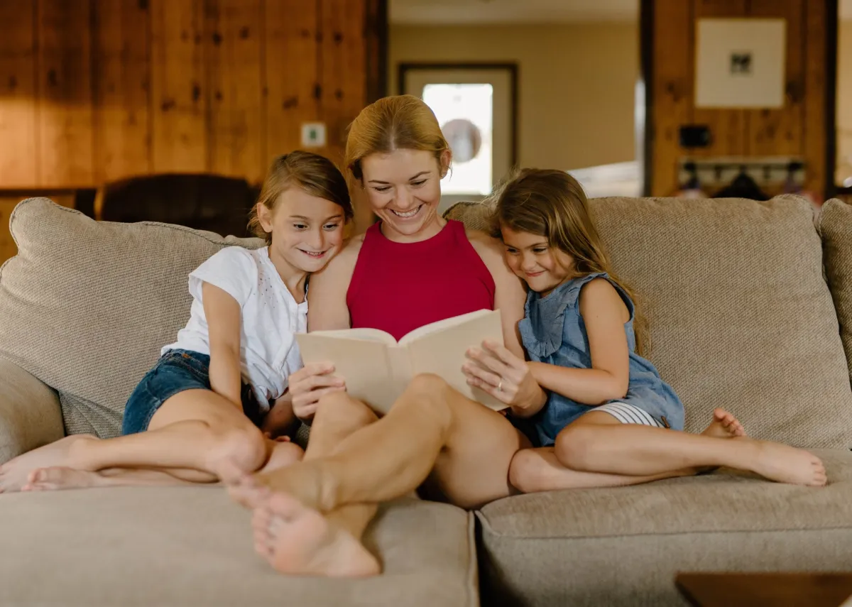 a sitter reading with two children