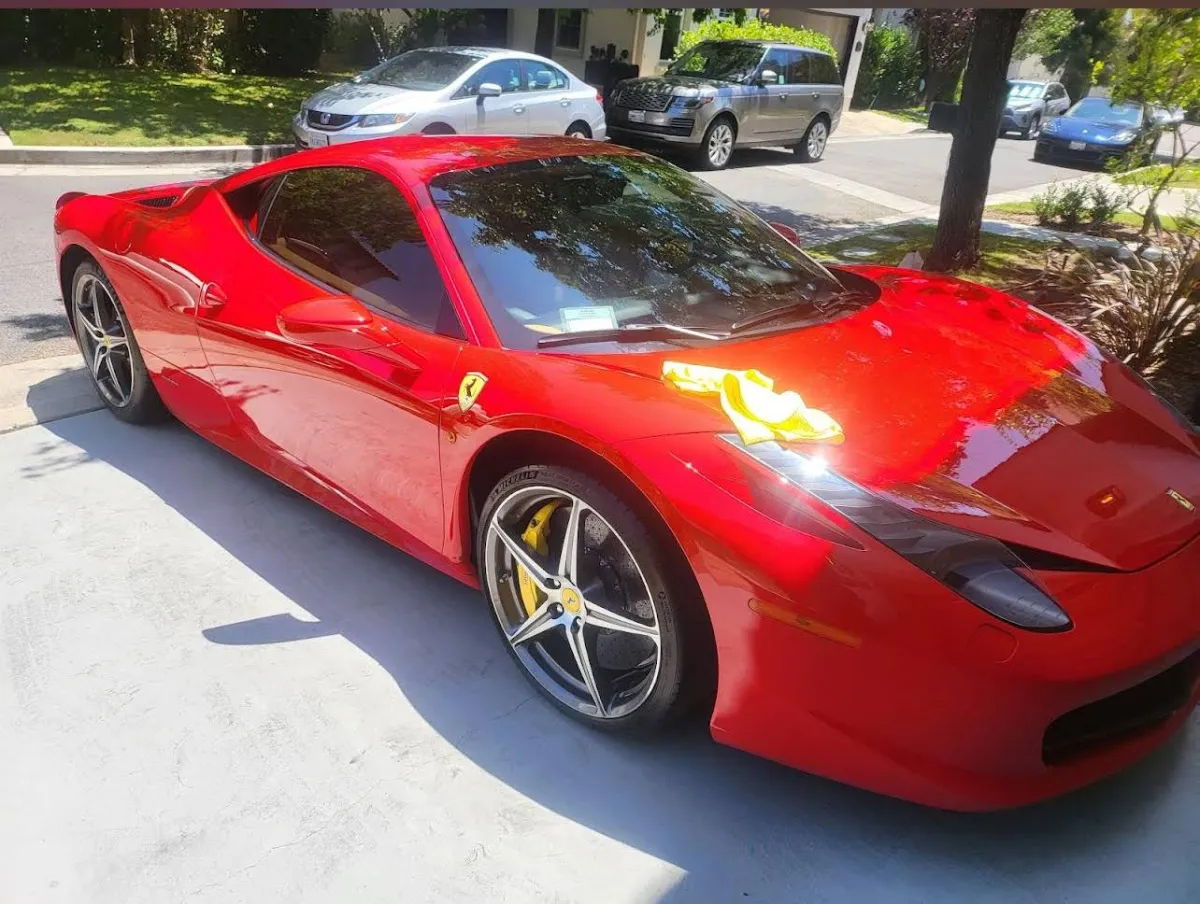 Red Ferrari 458 Italia with yellow microfiber towels on the hood after high-end mobile car wash in Los Angeles driveway