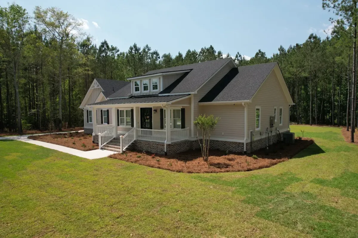 Alt Text: Beautifully mulched driveway lined with plants and trees, showing finished mulch delivery.