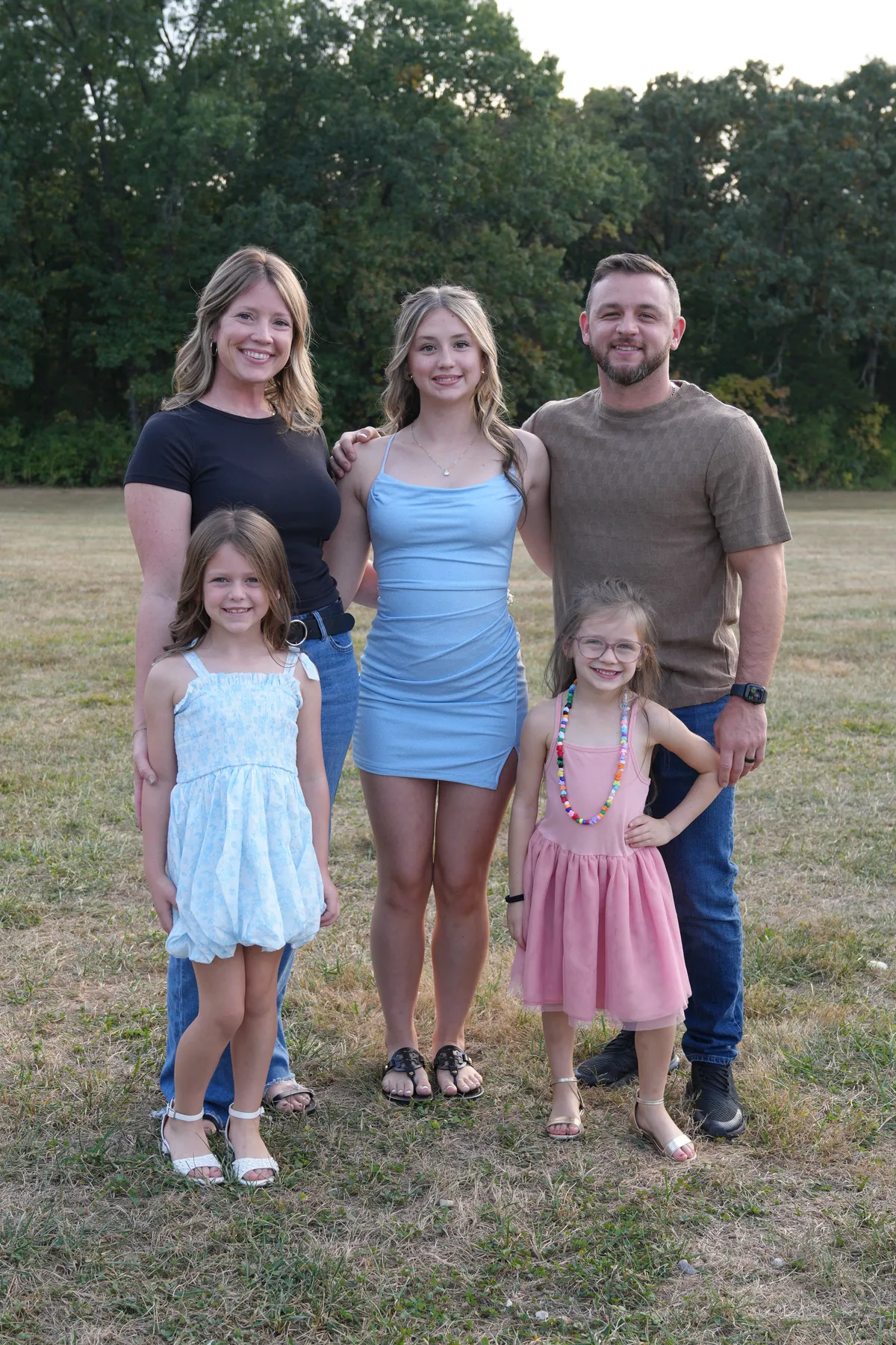 Joey Miller sharing a genuine outdoor golden hour laugh with his three daughters