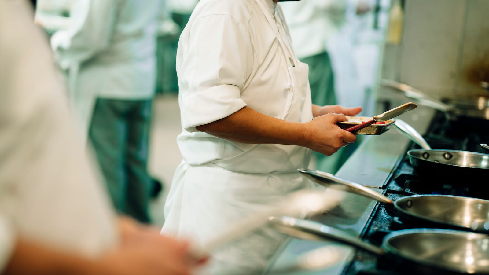 Culinary student cooking in a professional kitchen with commercial equipment