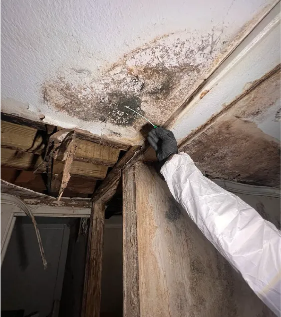 A red fire hydrant sitting on the side of a cement wall