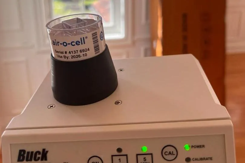 A red fire hydrant sitting on the side of a cement wall