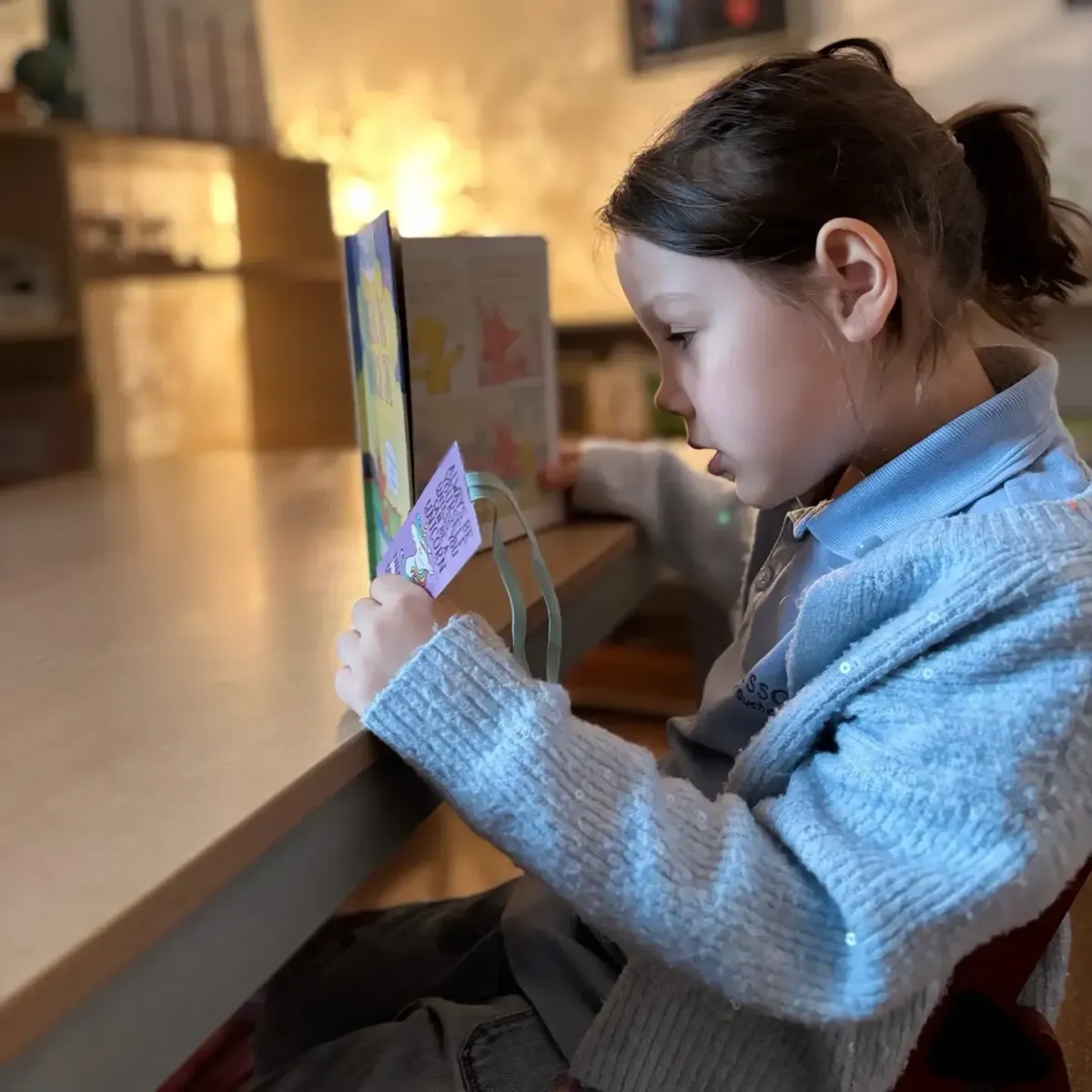 Patru copii cu vârste între 3–5 ani jucându-se colaborativ cu materiale Montessori într-o sală luminoasă.