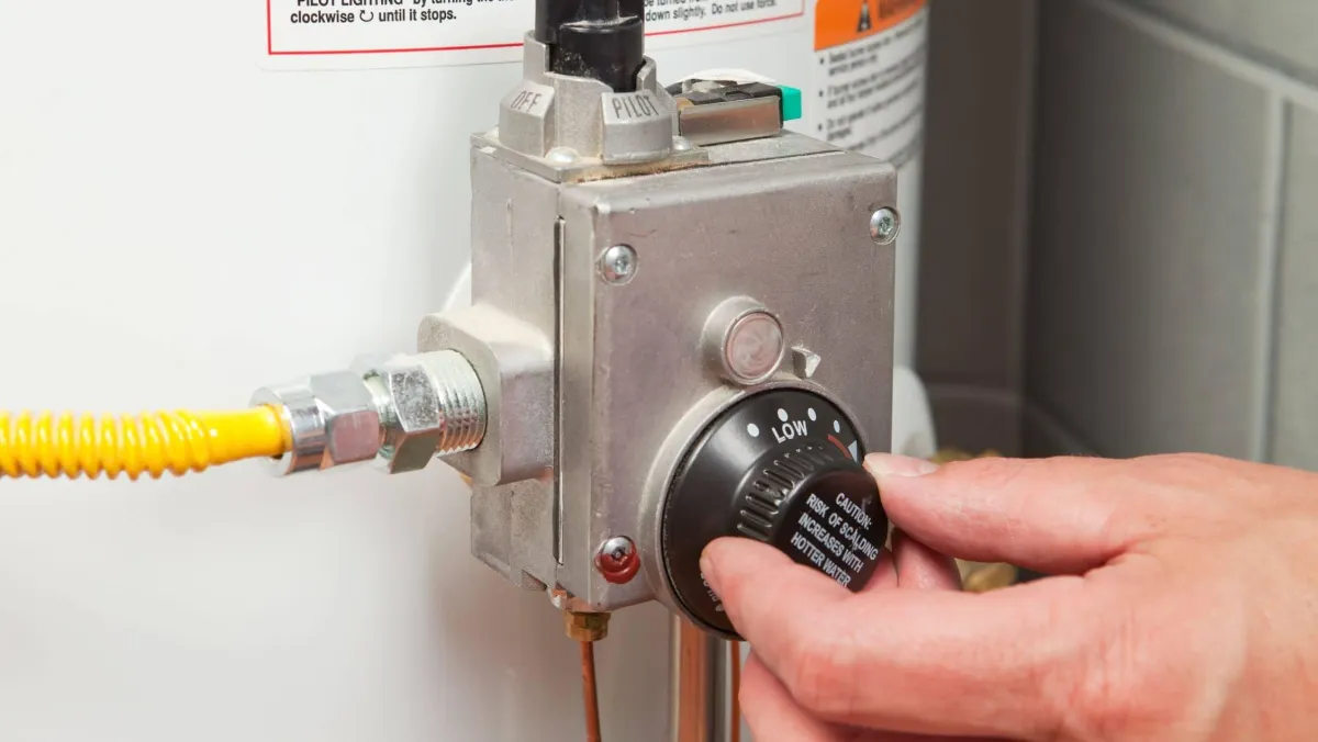 hand repairing water heater thermostat 