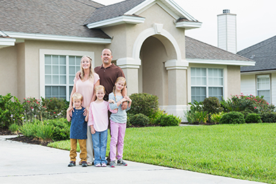 midwest family standing in front of their home
