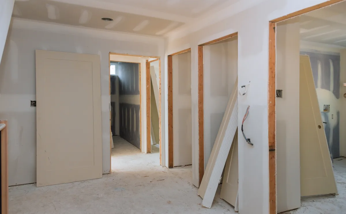 Interior home renovation with drywall installation and unfinished doors.