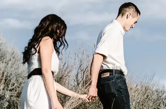 tree on body of water near mountains
