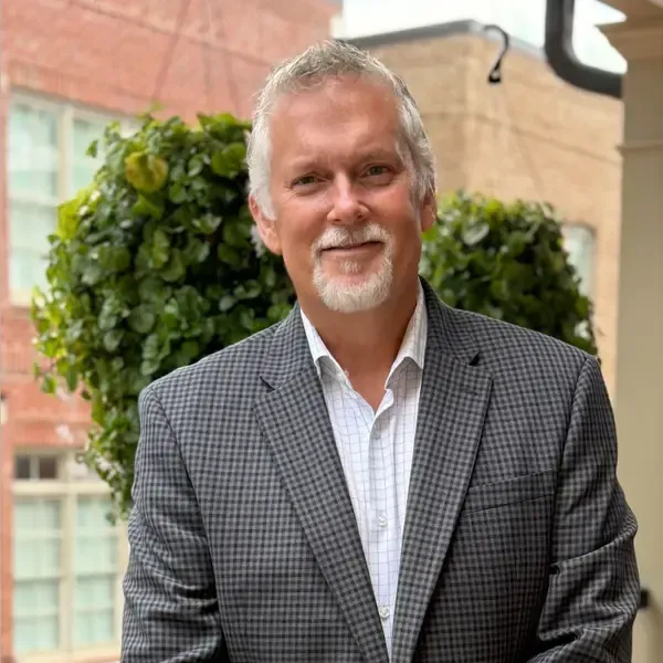 Portrait of James Dicke smiling in a suit.