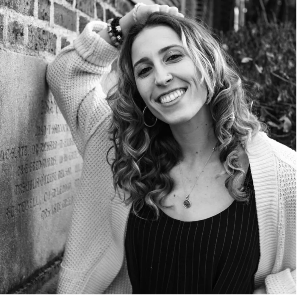 Portrait of Ali Banks smiling with curly hair.