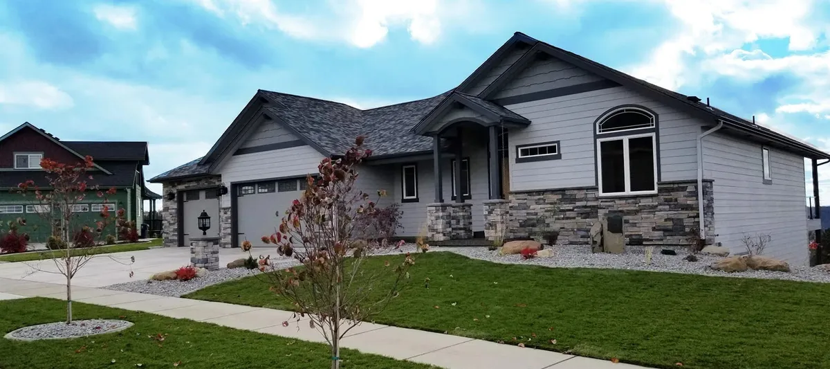 Finished custom home exterior with stone accents and craftsman details, built by Johnson Brothers Construction in Spokane, WA