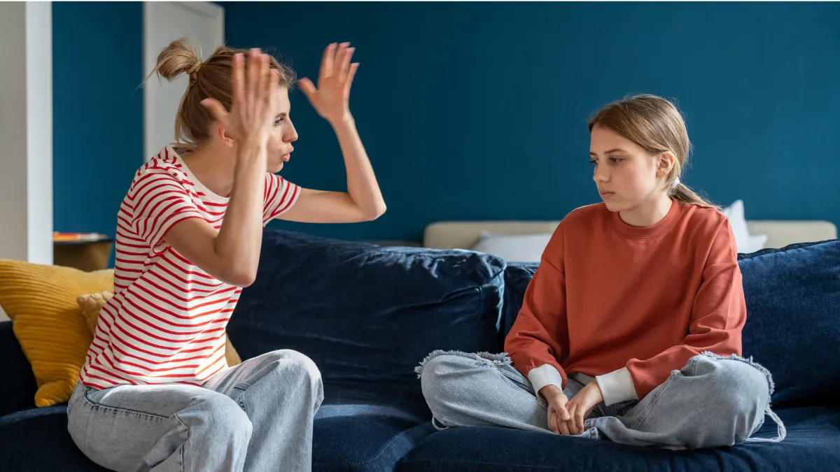 A parent reacting with frustration to her anxious teenage child at home, representing emotional overwhelm, conflict, and anxiety in children.