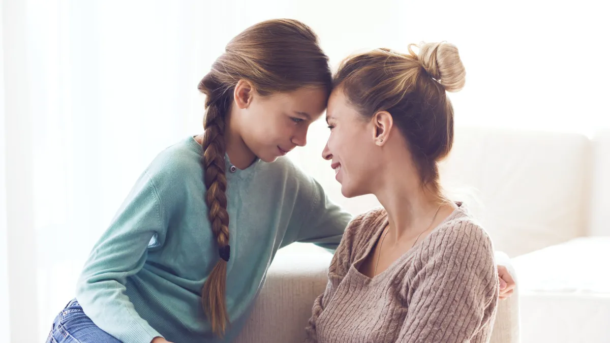 Mother comforting her child with a gentle forehead touch, representing emotional safety, connection, and calming support for child anxiety.