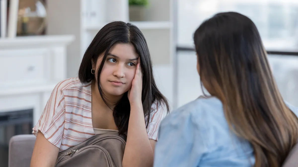 Parent having a calm, supportive conversation with a teenage daughter at home, demonstrating emotional connection, active listening, and a safe environment for discussing anxiety, emotions, and mental wellbeing.