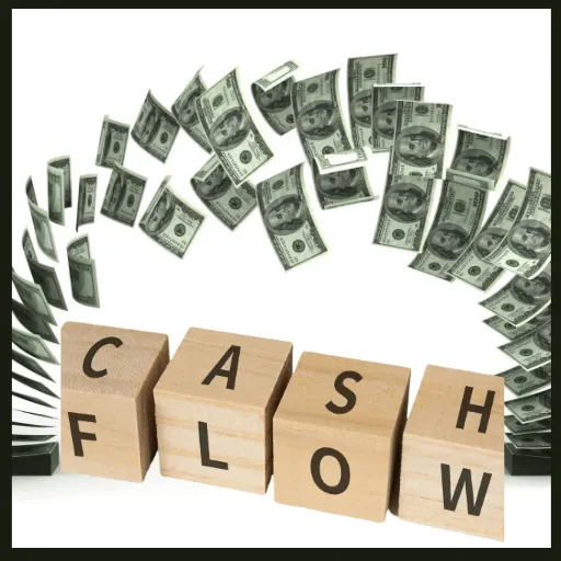 Image of the word cash flow on wood blcks with a arching flow of money above it.