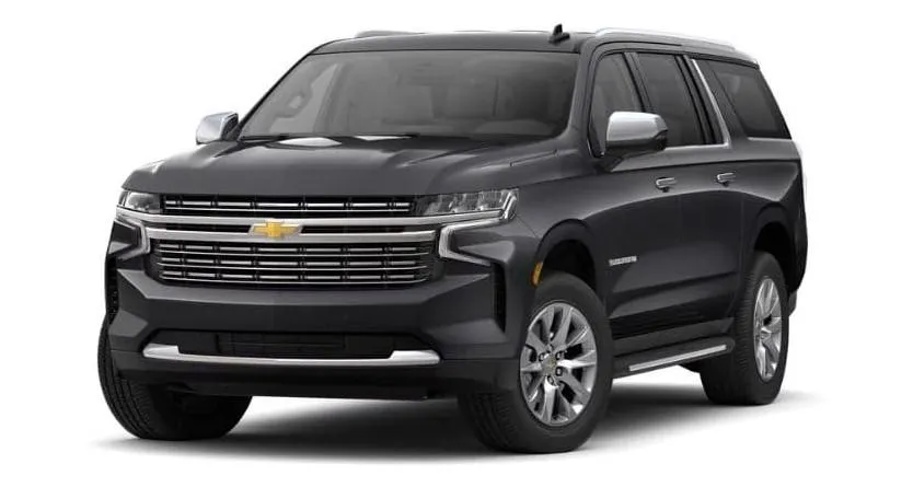 two brown wooden chairs beside the wall