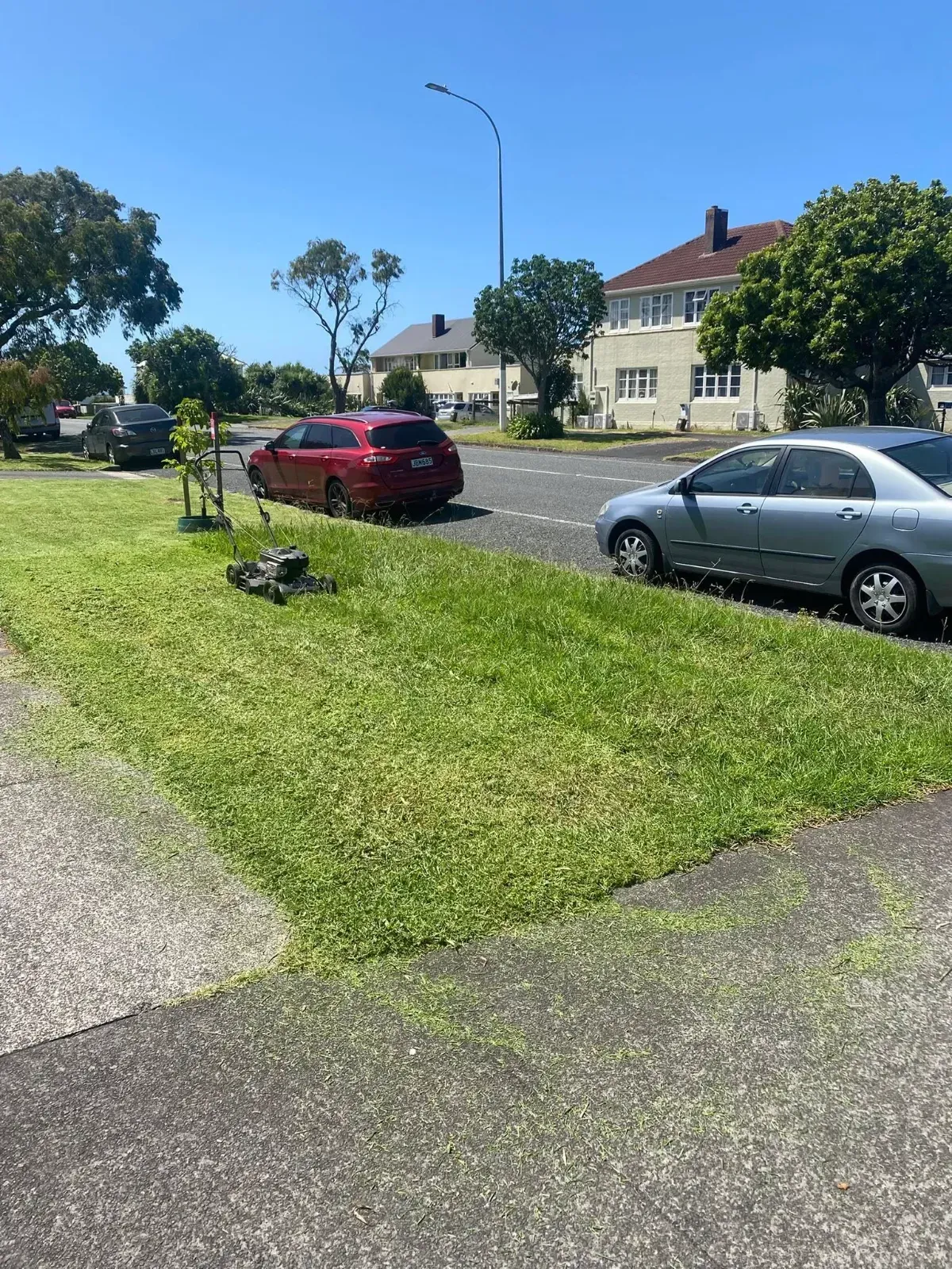 JNT Mowing Service mowing a roadside lawn in Auckland