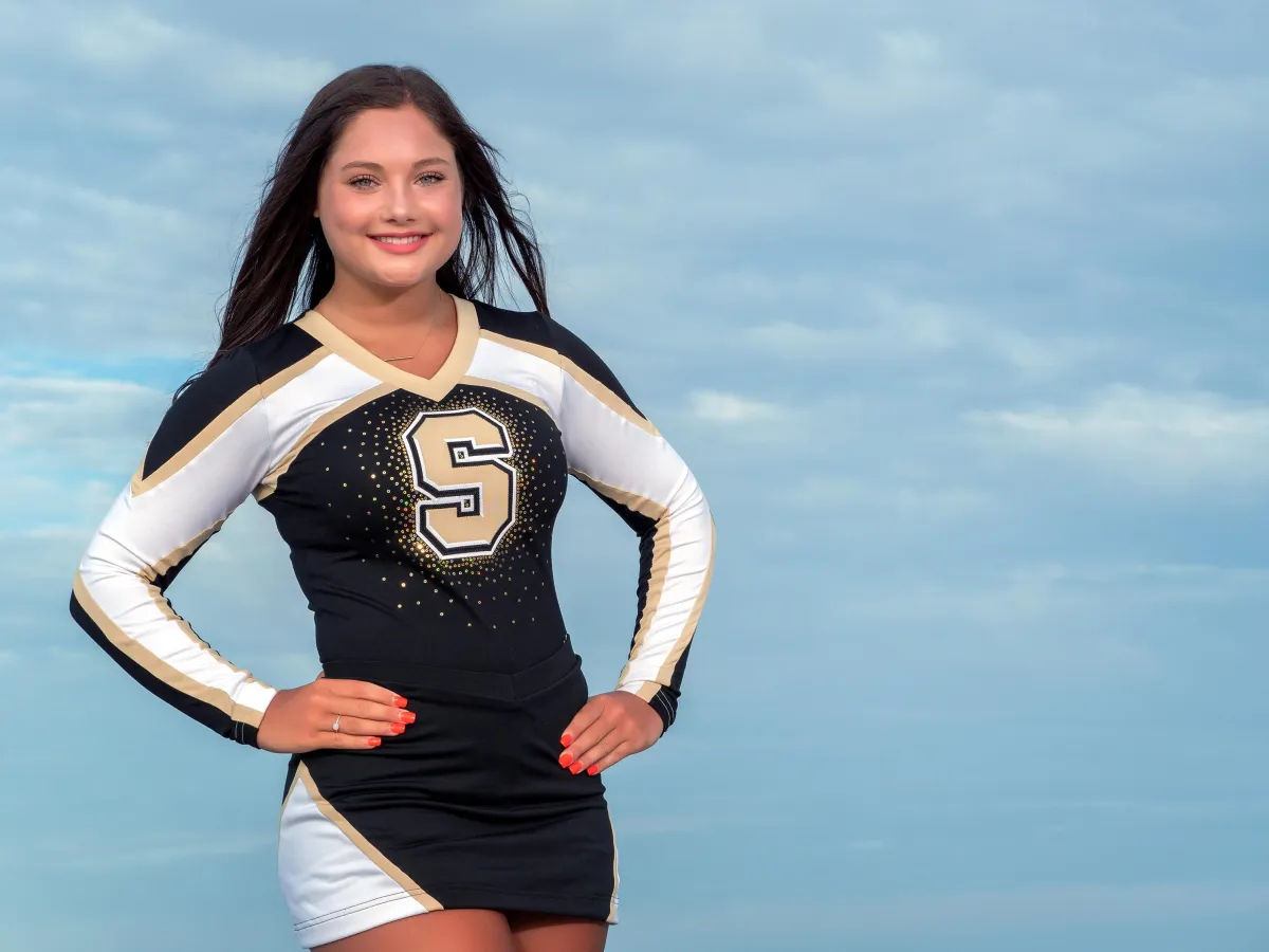 Hilton Head senior portrait of high school cheerleader in uniform during beach photo session