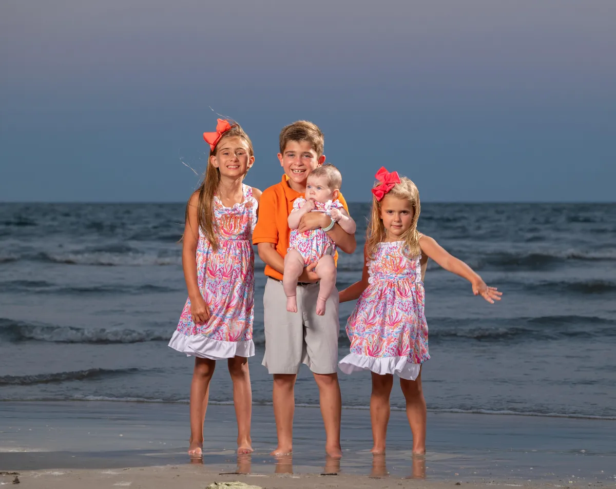 Siblings standing barefoot on the beach during a sunset photo session on Hilton Head Island, captured by Seaside Beach Photography.