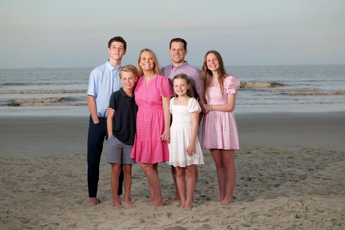 Family of six standing together on the beach at sunset during a Hilton Head Island photography session