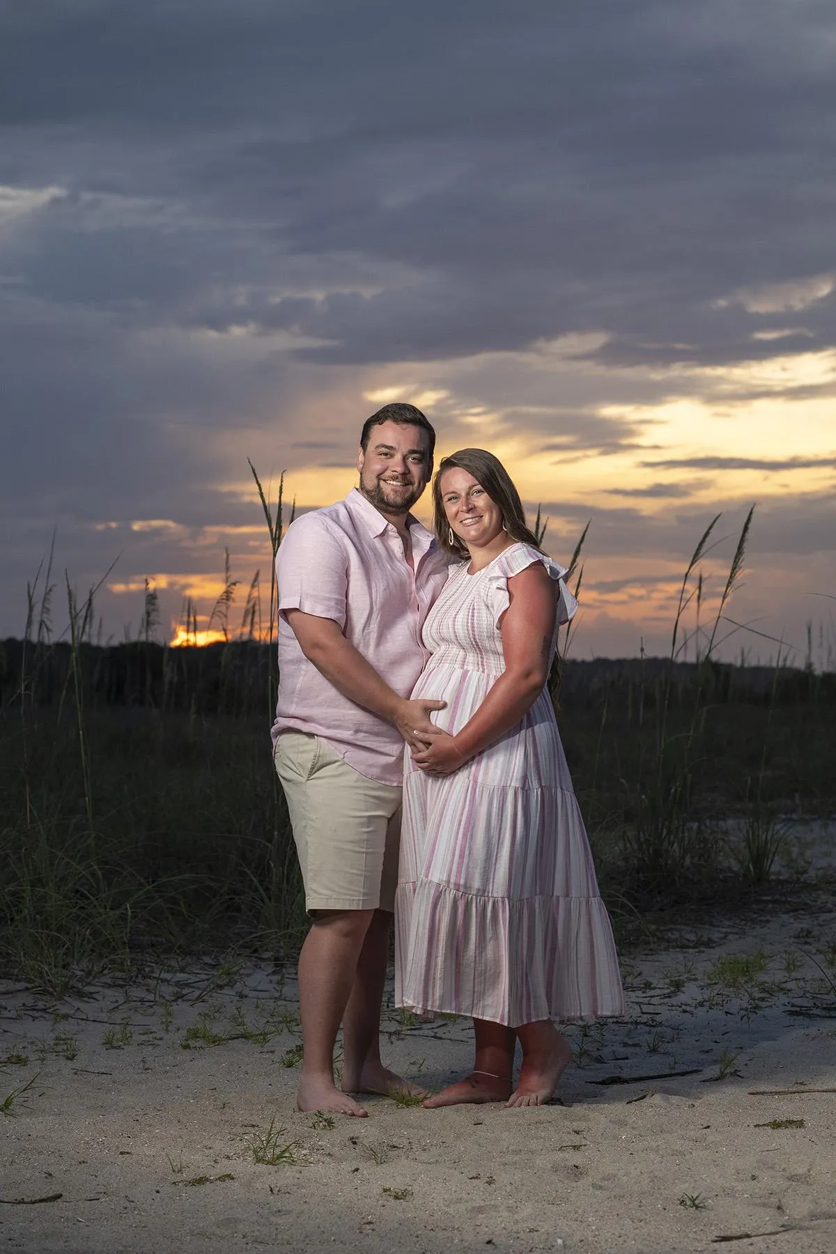 Couple holding baby bump during a maternity beach photo session at sunset on Hilton Head Island