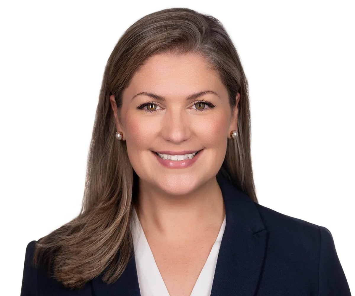 Classic corporate headshot on white — straight-on pose, confident posture.