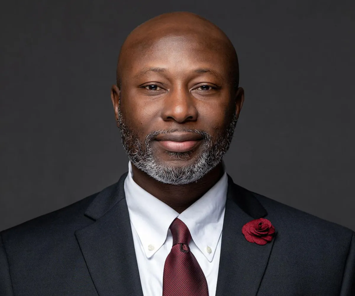 Polished business headshot on soft gray gradient — neutral, on-brand look.