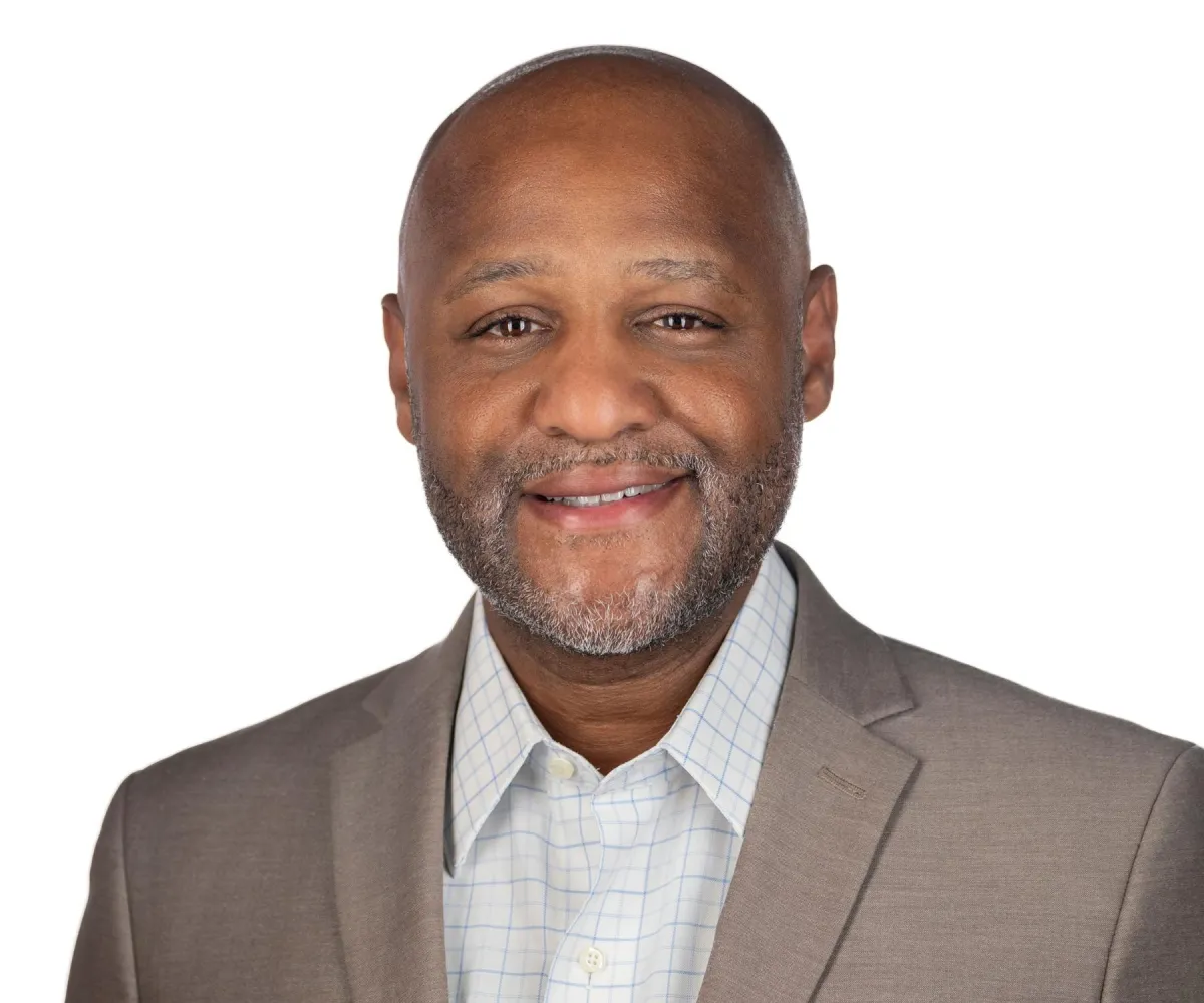 Branding headshot on white — friendly smile, camera-aware eye contact.