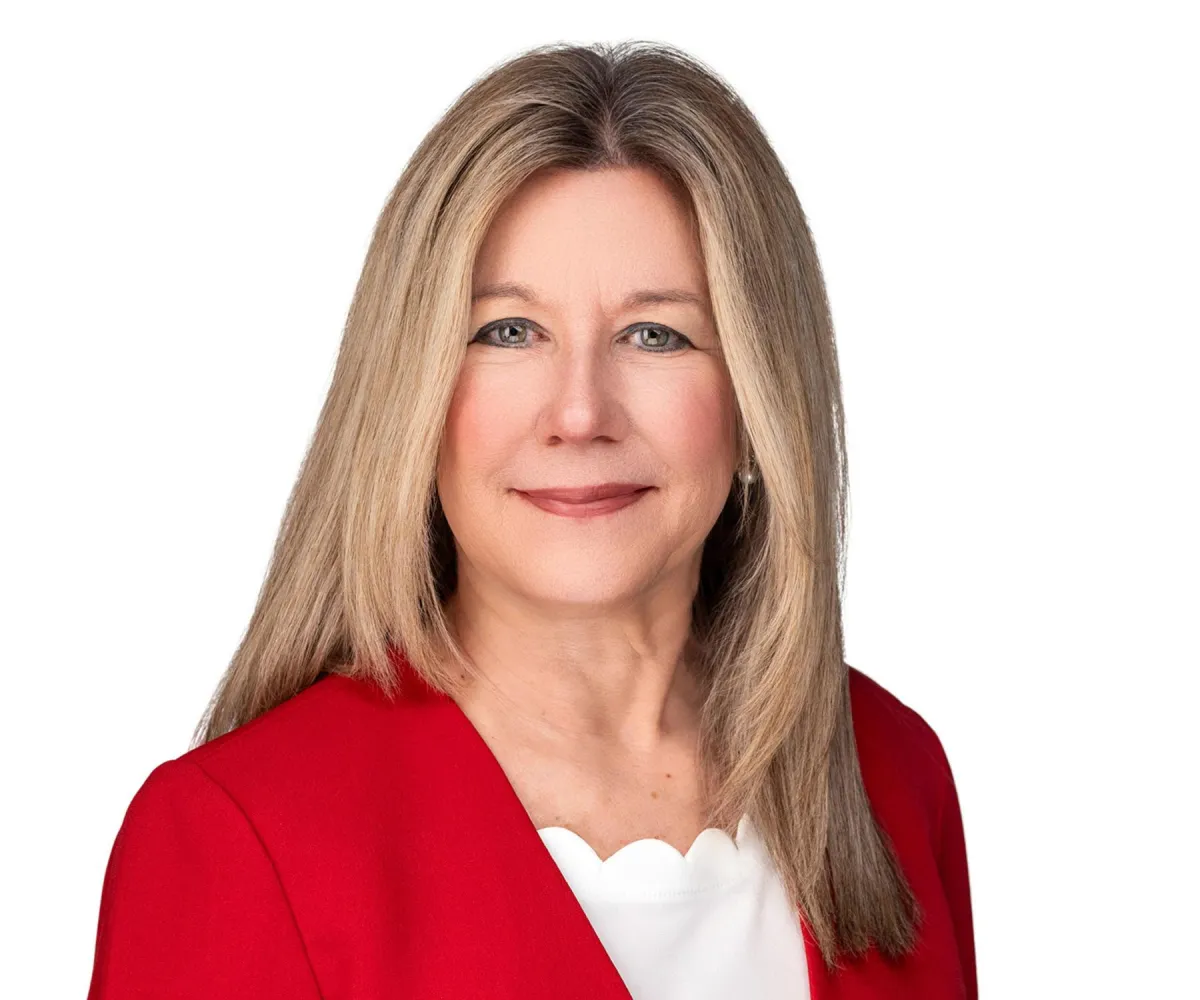 Leadership headshot on white — formal jacket, professional styling.