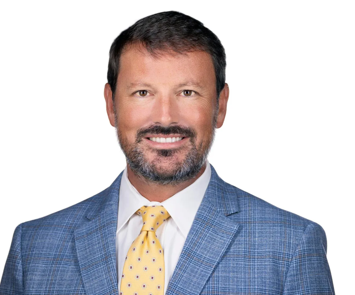 Modern headshot on white backdrop — subtle angle, relaxed smile.