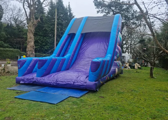 Big purple slide that has been hired and put in someones back garden
