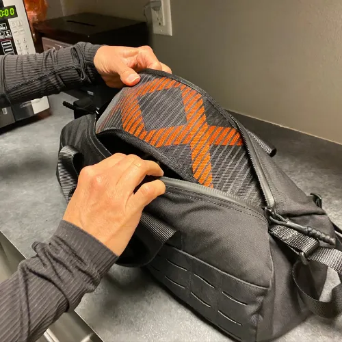 Close-up of hands adjusting the BFX Stretch strap and back support pad.