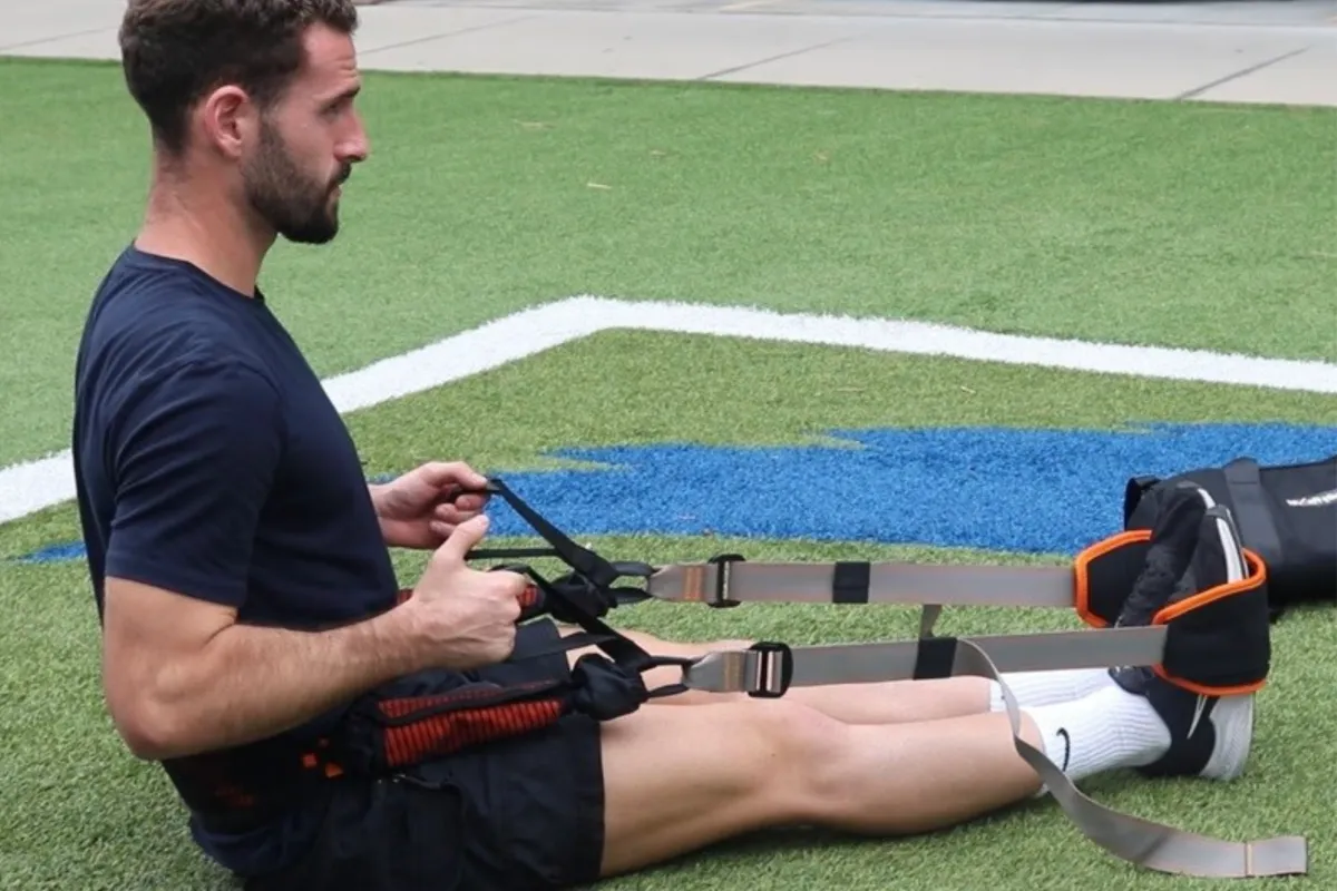Active adult seated outdoors using BFX Stretch with one leg extended.