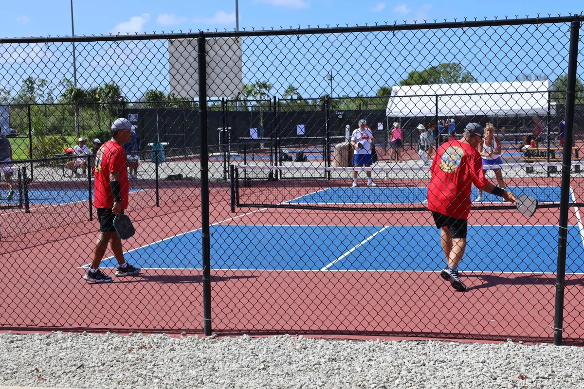 Pickleball players competing in a doubles match on an outdoor court.