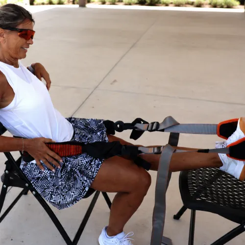 Active adult seated in a chair using BFX Stretch to stretch one leg at a time.