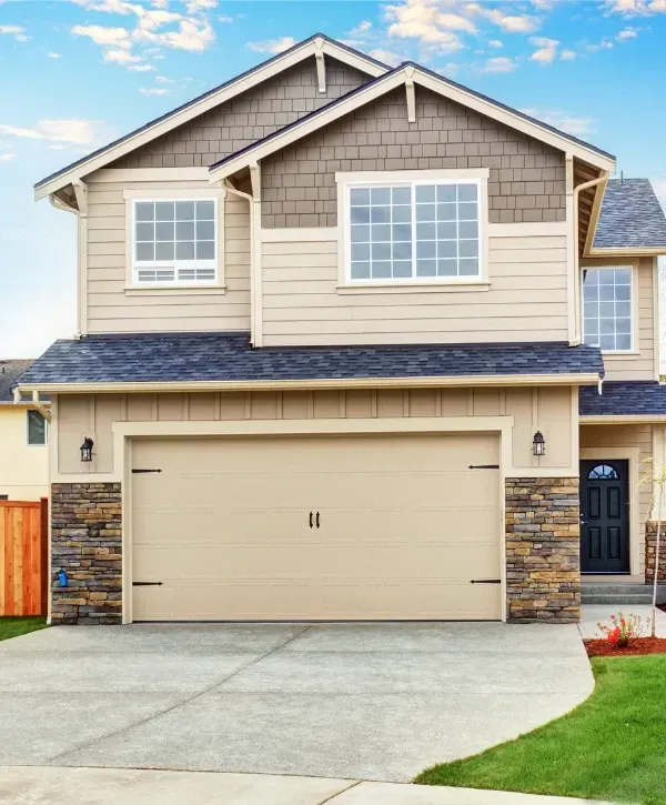 Suburban house with beige garage door and stone accent walls