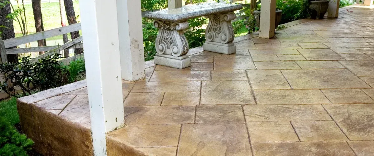 Decorative stamped concrete front porch with stone bench